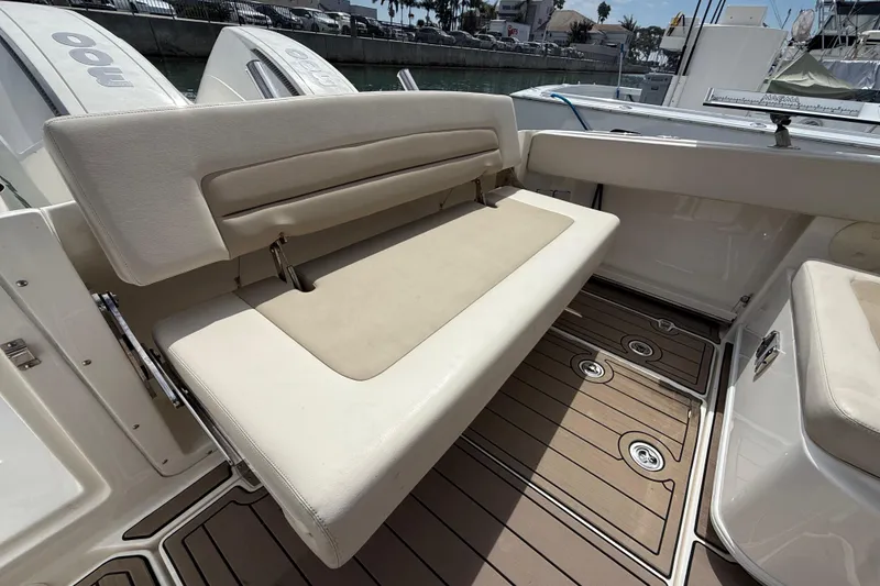 Slide: The Image of 2023 Boston Whaler 320 Vantage boat interior with beige seating and wooden deck. - 11