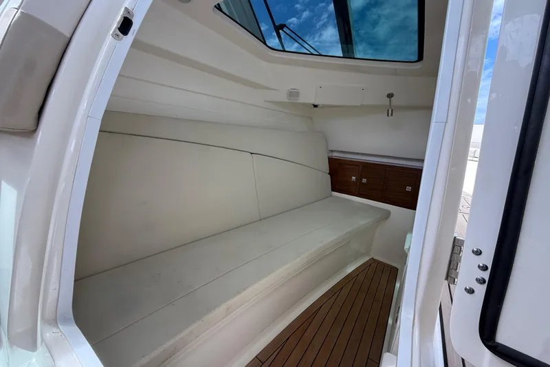 Slide: The Image of Interior cabin of 2023 Boston Whaler 320 Vantage with cushioned seating and wooden flooring. - 15