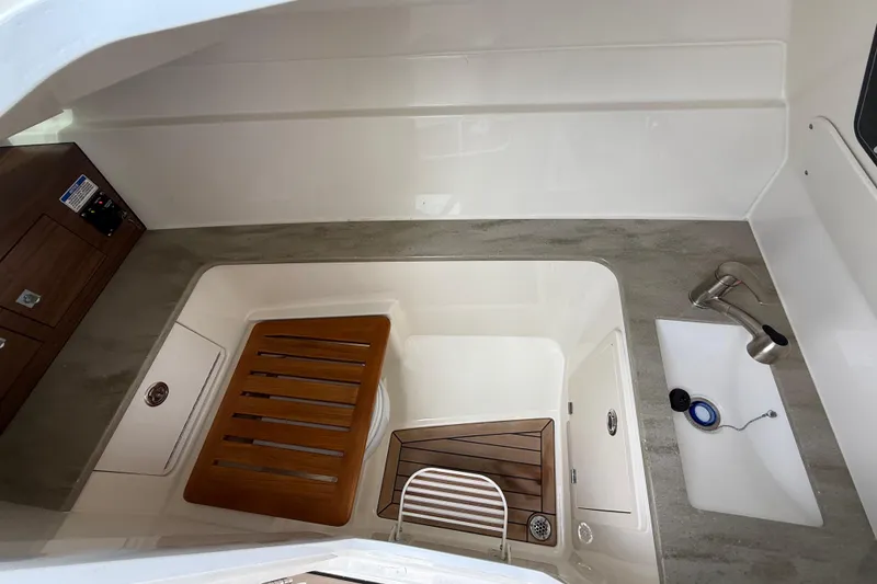 Slide: The Image of 2023 Boston Whaler 320 Vantage interior with sink and wooden accents. - 20