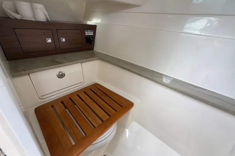 Slide: The Image of 2023 Boston Whaler 320 Vantage interior with wooden seat and storage cabinets. - 21