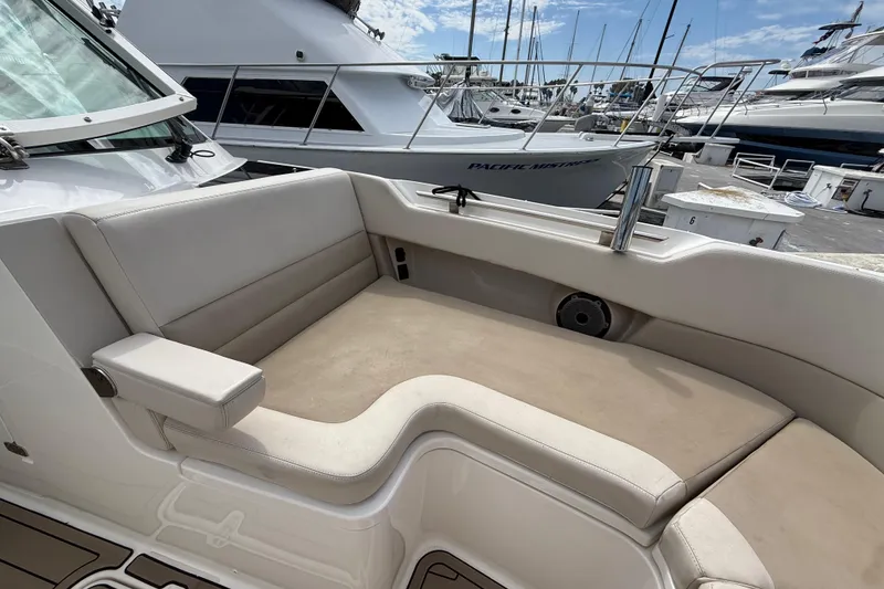 Slide: The Image of 2023 Boston Whaler 320 Vantage boat interior with cushioned seating at marina. - 23