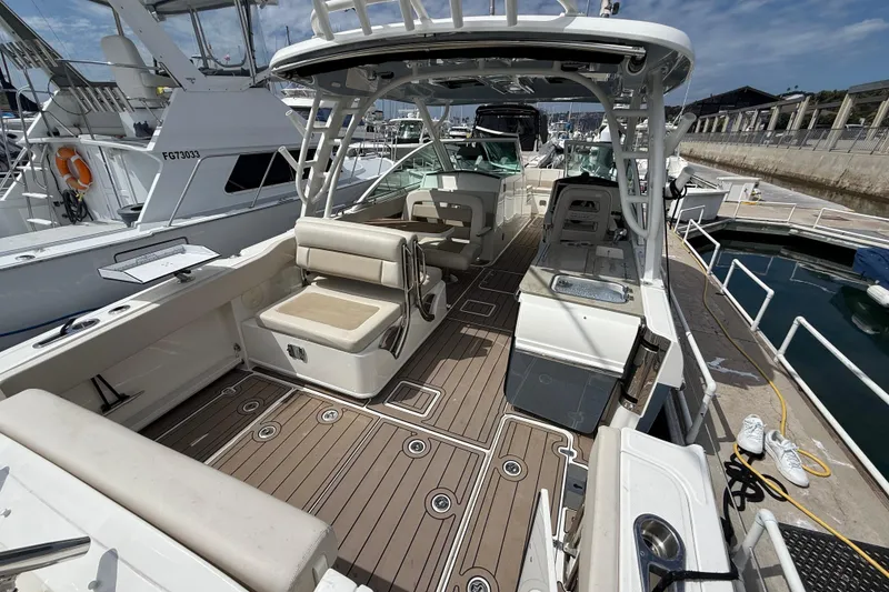 Slide: The Image of 2023 Boston Whaler 320 Vantage boat interior with seating and deck at marina. - 7