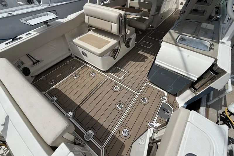 Slide: The Image of 2023 Boston Whaler 320 Vantage interior with cushioned seating and sleek deck design. - 8