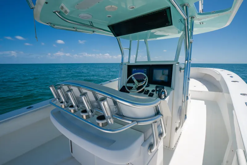Slide: The Image of 2006 Venture 39 Open boat helm with ocean view, featuring modern controls and rod holders. - 20