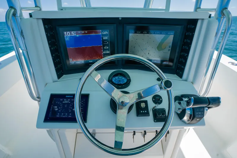 Slide: The Image of 2006 Venture 39 Open boat helm with navigation screens and steering wheel. - 24