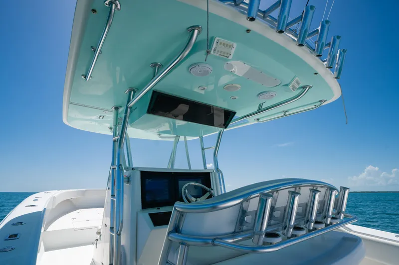 Slide: The Image of 2006 Venture 39 Open boat helm with rod holders, under clear blue sky. - 26