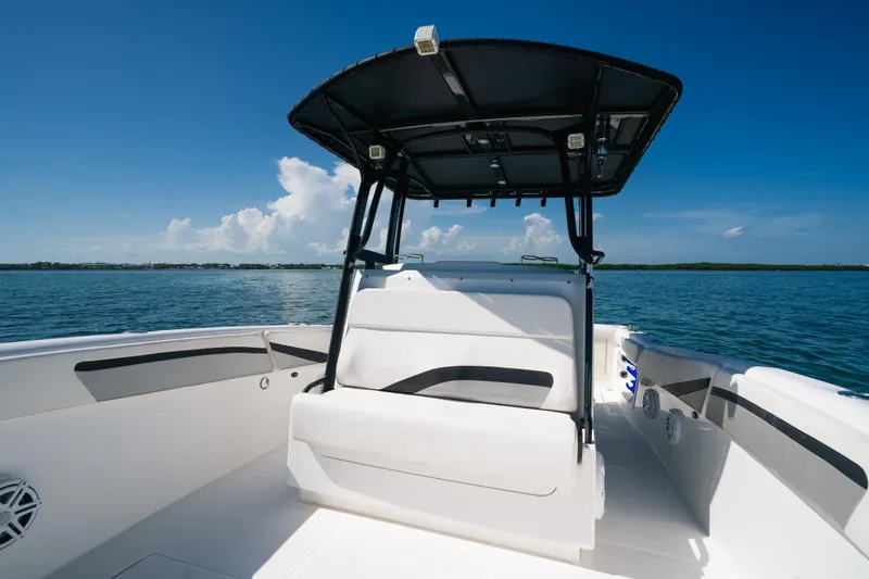 Slide: The Image of 2013 Deep Impact 33 boat interior with seating, under a clear blue sky on calm waters. - 14