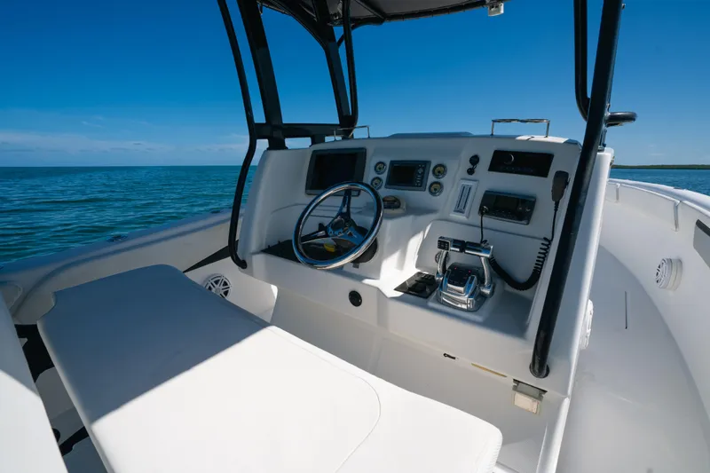 Slide: The Image of Cockpit of 2013 Deep Impact 33 boat with steering wheel and controls, on open water. - 15