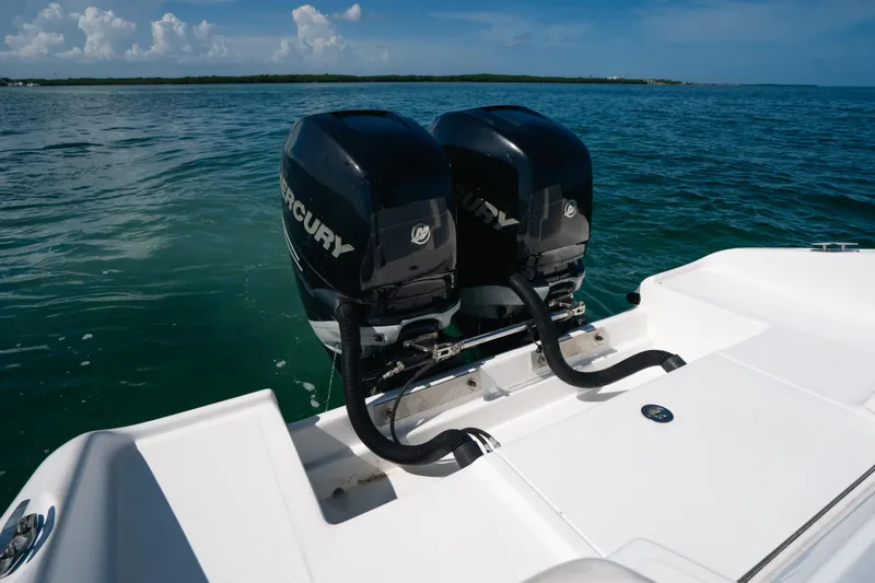 Slide: The Image of Twin Mercury outboard engines on a 2013 Deep Impact 33 boat, cruising on clear blue waters. - 22