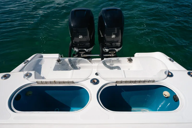 Slide: The Image of 2013 Deep Impact 33 boat with dual engines and open livewells on calm water. - 24