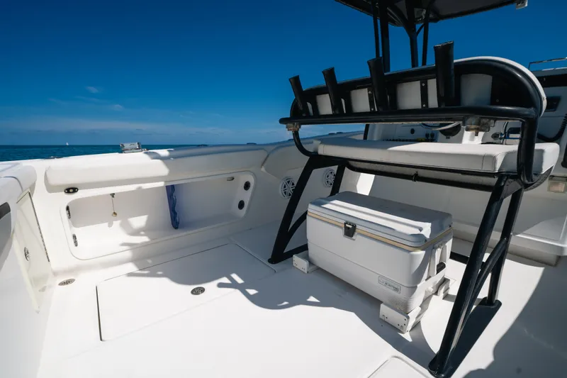 Slide: The Image of 2013 Deep Impact 33 boat interior with seating and cooler under clear blue sky. - 25
