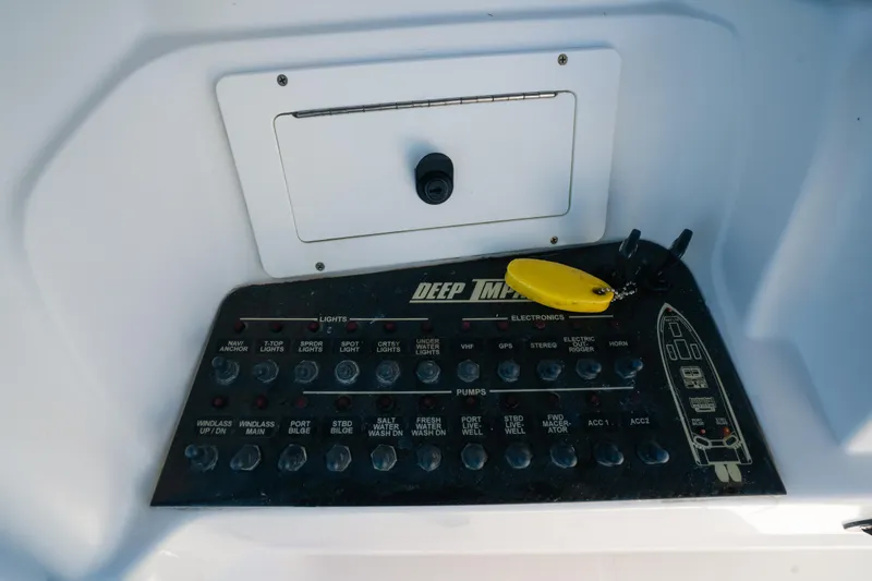 Slide: The Image of Control panel of a 2013 Deep Impact 33 boat with switches and key fob. - 26