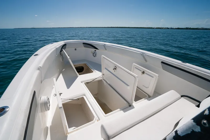 Slide: The Image of 2013 Deep Impact 33 boat with open storage compartments on calm ocean water. - 27