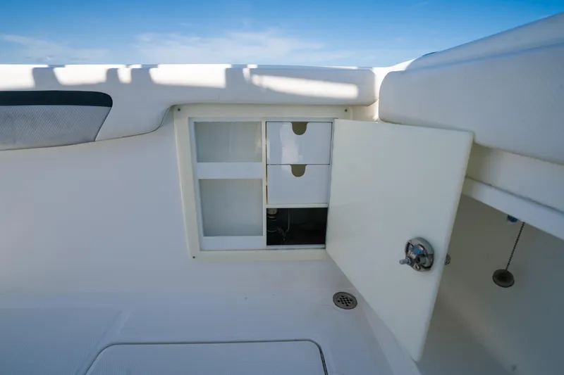 Slide: The Image of Open storage compartment on a 2013 Deep Impact 33 boat, featuring drawers and a latch. - 28
