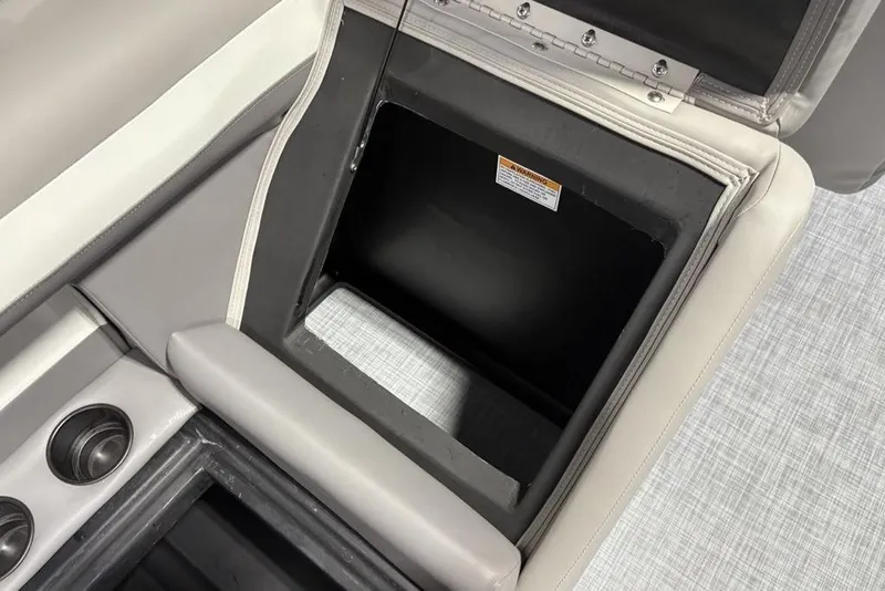 Slide: The Image of 2026 Premier 220 Sunscape RF boat storage compartment with cup holders and cushioned seating. - 28