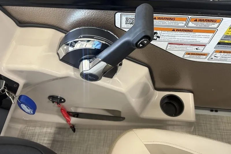 Slide: The Image of Control panel of 2026 Premier 220 Sunscape RF boat with throttle lever and warning labels. - 21