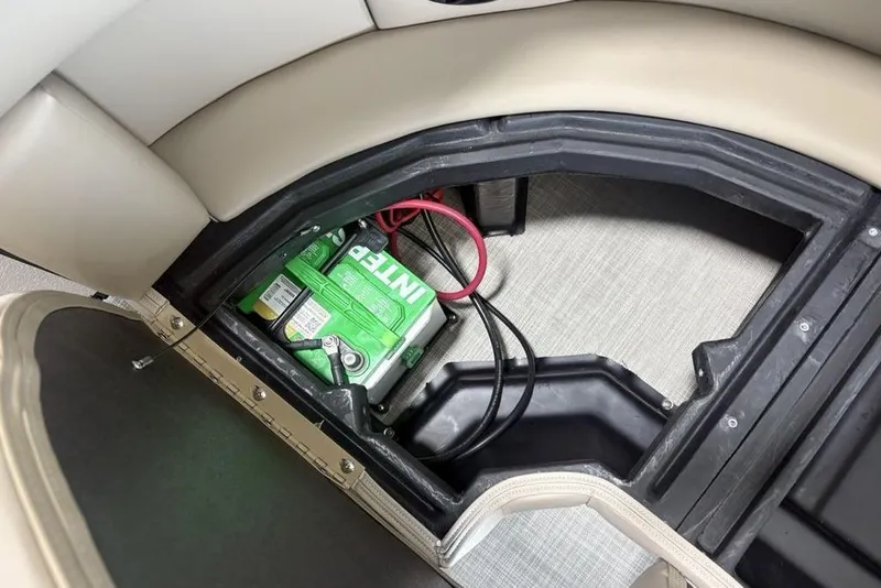 Slide: The Image of Battery compartment of 2026 Premier 220 Sunscape RF boat with green battery and cables. - 24