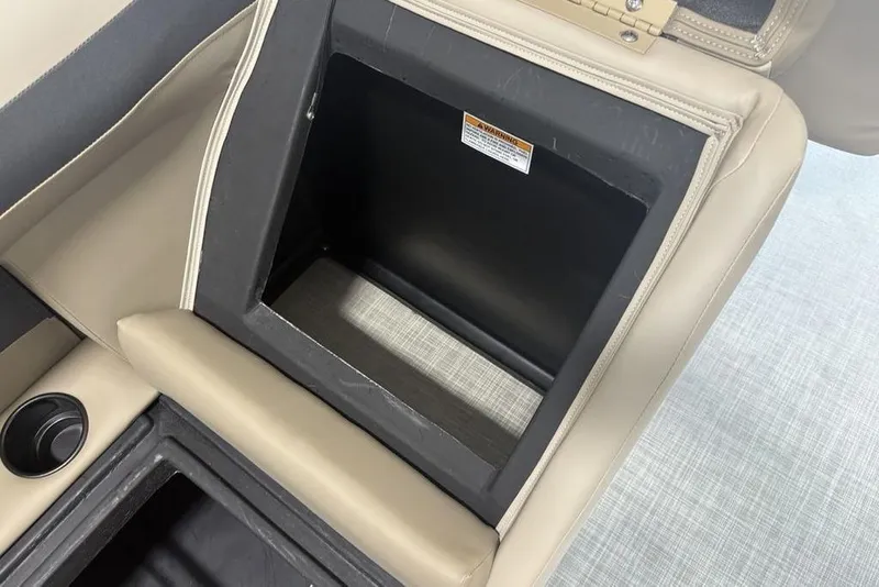 Slide: The Image of 2026 Premier 220 Sunscape RF boat storage compartment with beige upholstery and cup holder. - 25