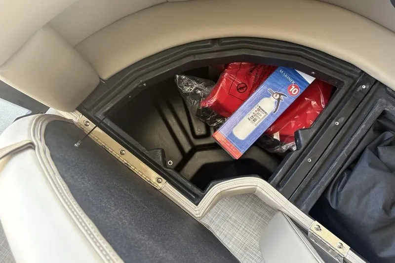 Slide: The Image of Storage compartment in 2026 Premier 220 Sunscape RF with fire extinguisher and safety gear. - 5
