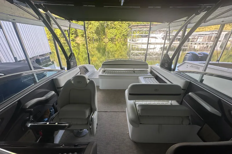 Slide: The Image of 2018 Cobalt R5 boat cruising on a scenic lake with lush green shoreline. - 10