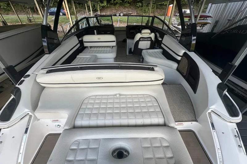 Slide: The Image of 2018 Cobalt R5 boat cruising on a scenic lake with lush green shoreline. - 2