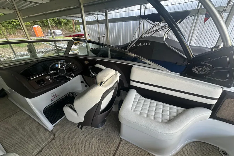 Slide: The Image of 2018 Cobalt R5 boat cruising on a scenic lake with lush green shoreline. - 3