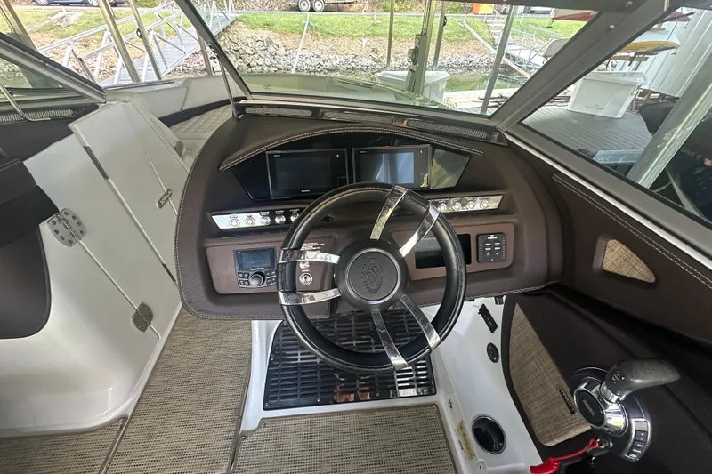 Slide: The Image of 2018 Cobalt R5 boat cruising on a scenic lake with lush green hills. - 7