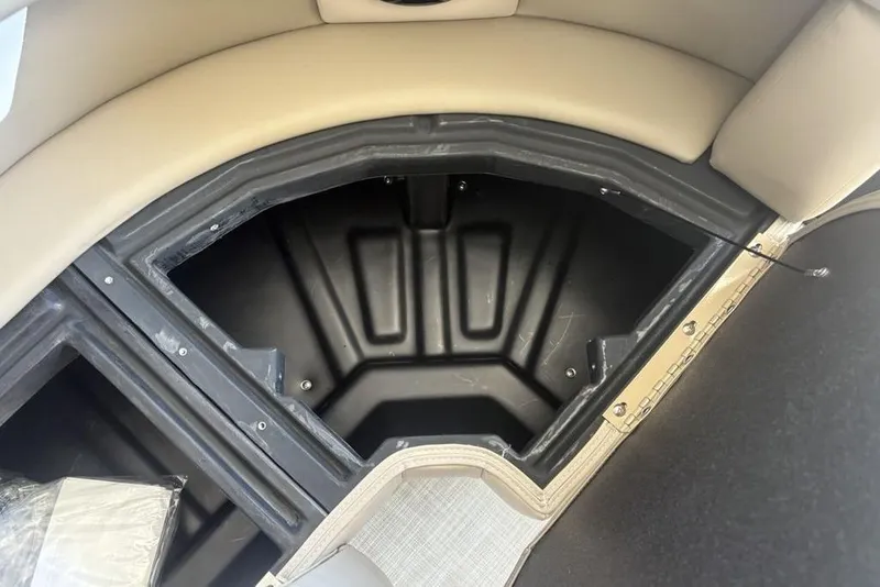 Slide: The Image of Open storage compartment in 2026 Premier 220 SUNSCAPE RL boat, featuring beige seating. - 10