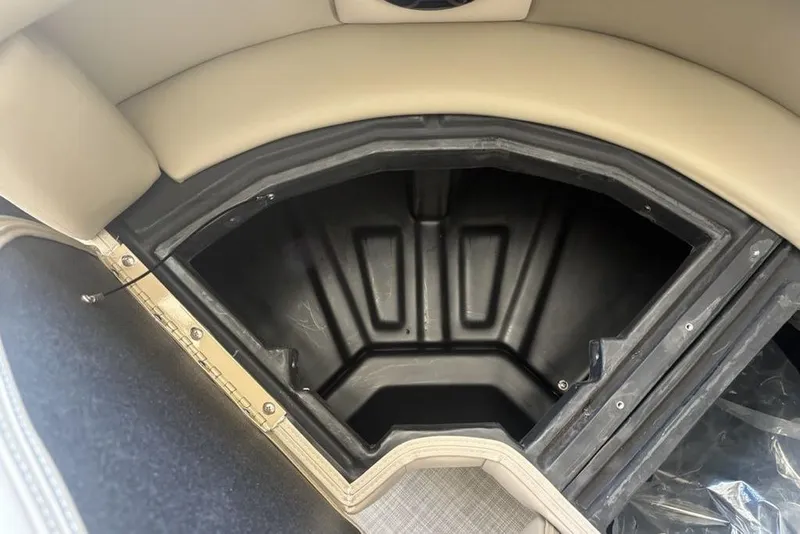 Slide: The Image of 2026 Premier 220 SUNSCAPE RL boat interior with storage compartment and cup holders. - 23