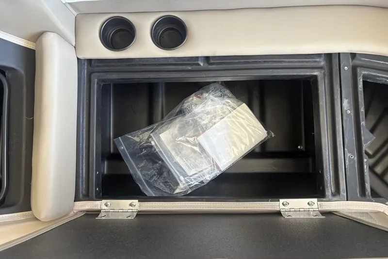 Slide: The Image of 2026 Premier 220 SUNSCAPE RL boat storage compartment with beige seating and black interior. - 7