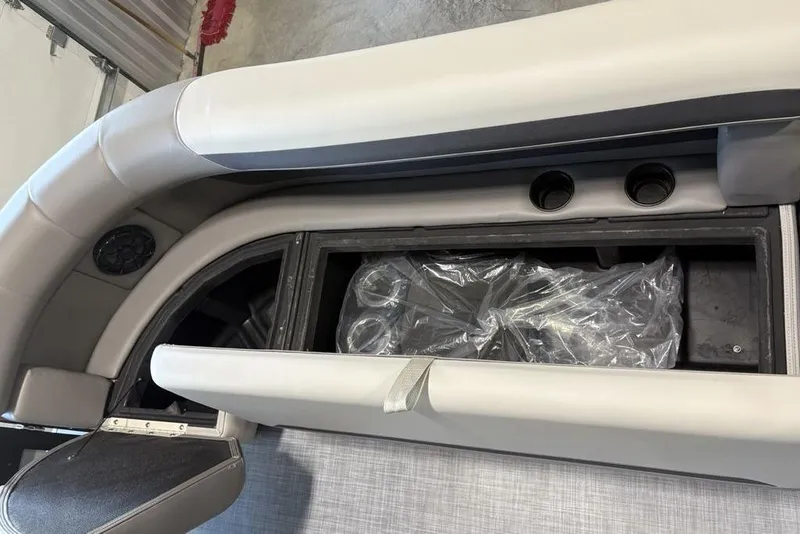 Slide: The Image of 2026 Premier 220 SUNSCAPE RL boat interior storage compartment with cup holders. - 4