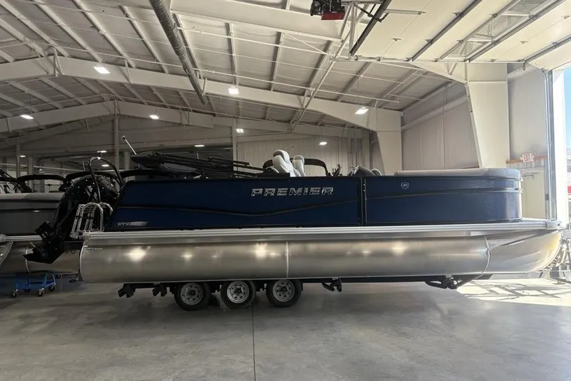 The Image of 2026 Premier 220 SUNSCAPE RL pontoon boat in a spacious indoor showroom. - 0