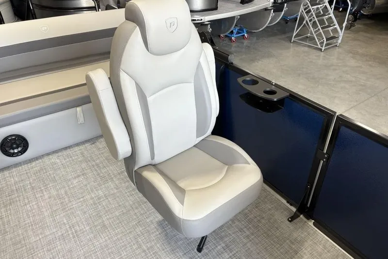 Slide: The Image of 2026 Premier 220 SUNSCAPE RL boat seat with armrests and cup holders in a showroom. - 16