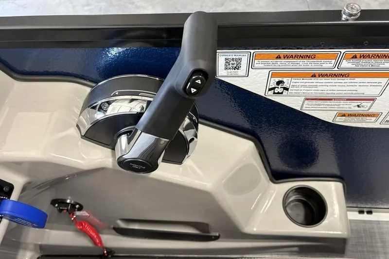 Slide: The Image of Premier 220 SUNSCAPE RL 2026 boat throttle control with warning labels and cup holder. - 18