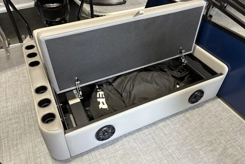 Slide: The Image of 2026 Premier 220 SUNSCAPE RL boat storage compartment with cup holders and speaker. - 25