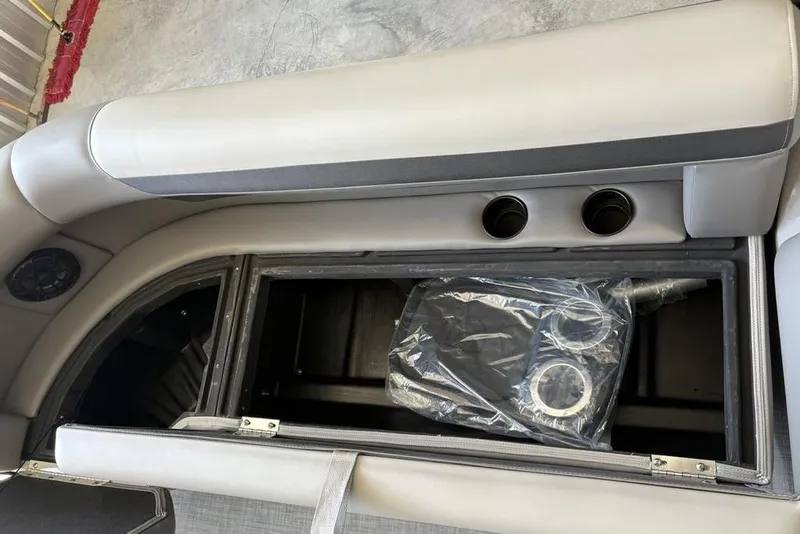 Slide: The Image of 2026 Premier 220 SUNSCAPE RL boat interior storage compartment with cup holders. - 1