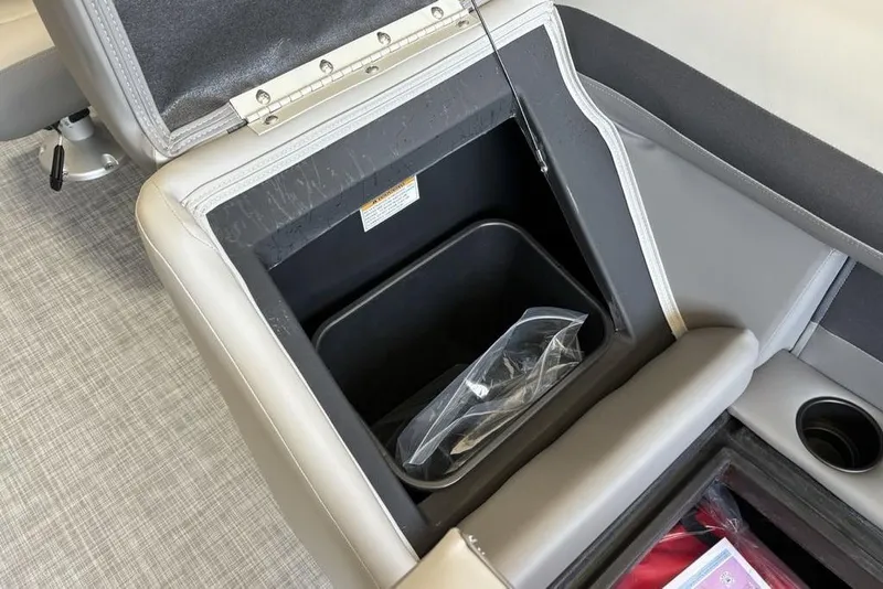 Slide: The Image of Open storage compartment in 2026 Premier 220 SUNSCAPE RL boat, featuring cup holder and interior bin. - 10