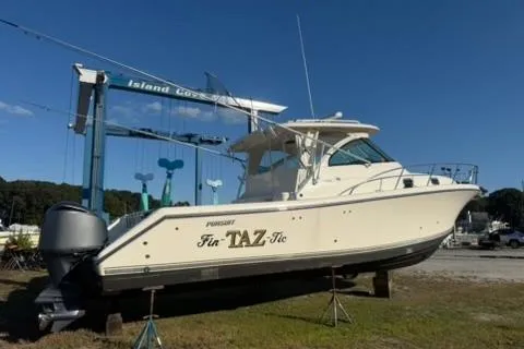 Slide: The Image of 2010 Pursuit OS 375 Offshore boat on land, under clear blue sky. - 1
