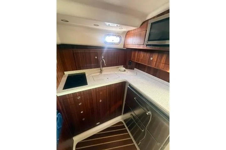 Slide: The Image of 2010 Pursuit OS 375 Offshore yacht interior with modern kitchen and wood cabinetry. - 13
