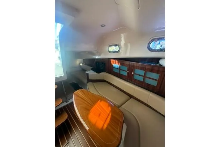 Slide: The Image of 2010 Pursuit OS 375 Offshore cabin interior with seating and wooden accents. - 14