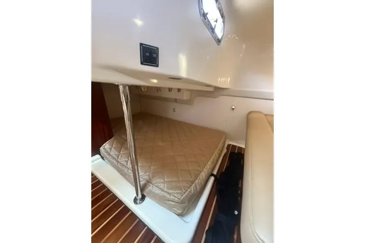 Slide: The Image of 2010 Pursuit OS 375 Offshore cabin interior with bed and wooden flooring. - 15
