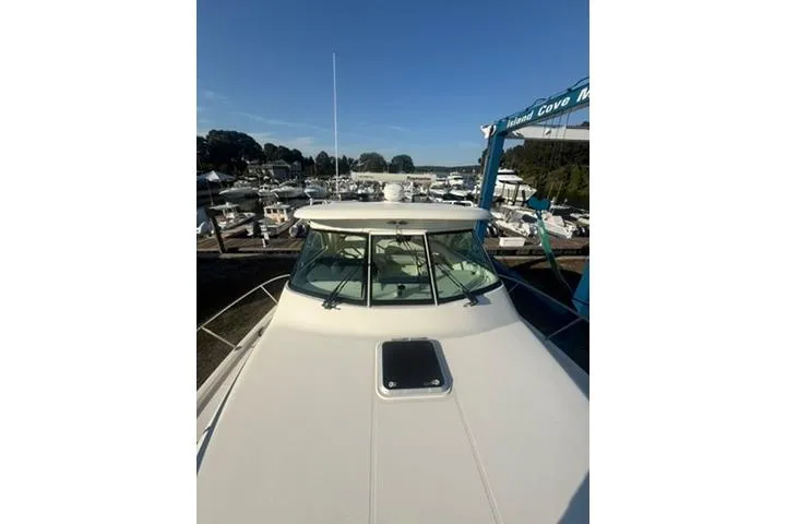 Slide: The Image of 2010 Pursuit OS 375 Offshore boat docked at a marina under clear blue skies. - 16