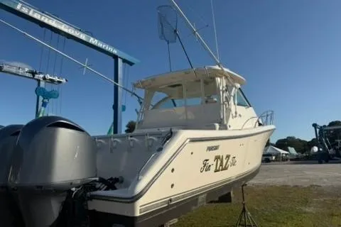 Slide: The Image of 2010 Pursuit OS 375 Offshore boat on land, dual engines, clear sky background. - 2