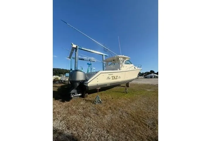 Slide: The Image of 2010 Pursuit OS 375 Offshore boat on land, under clear blue sky. - 3