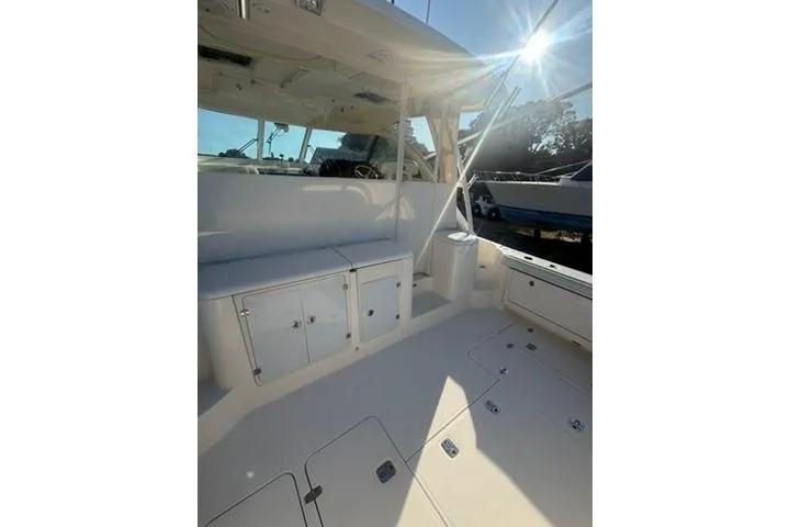 Slide: The Image of 2010 Pursuit OS 375 Offshore boat interior with seating and storage, sunlit deck. - 5