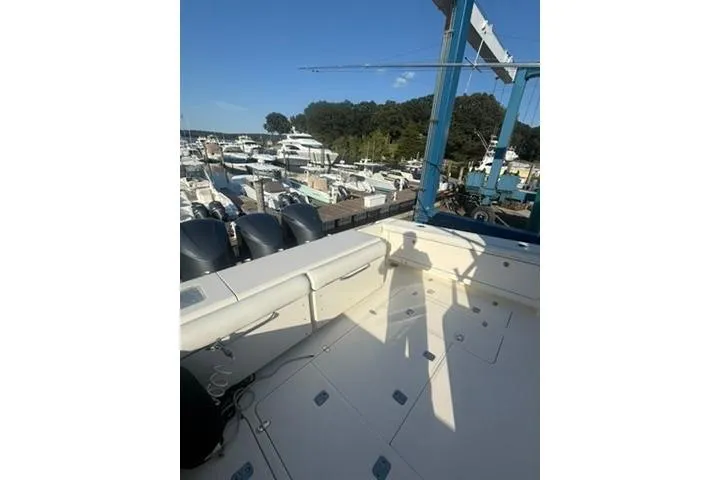 Slide: The Image of 2010 Pursuit OS 375 Offshore boat deck at marina, sunny day, multiple yachts in background. - 6