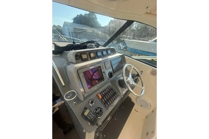 Slide: The Image of 2010 Pursuit OS 375 Offshore boat dashboard with navigation controls and steering wheel. - 8