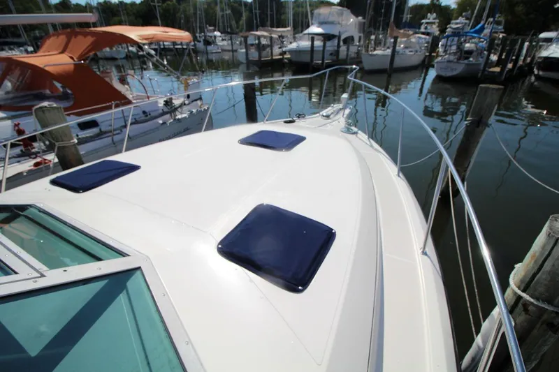 Slide: The Image of 1996 Tiara Yachts 3300 Open docked at marina, showcasing sleek deck design. - 12