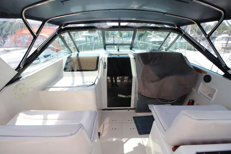 Slide: The Image of 1996 Tiara Yachts 3300 Open cockpit with seating and covered helm, docked at marina. - 14