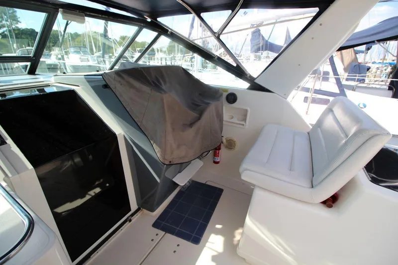 Slide: The Image of 1996 Tiara Yachts 3300 Open cockpit with seating and covered controls, docked at marina. - 16